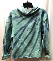 Front view of tie-dye cropped hoodie on hanger