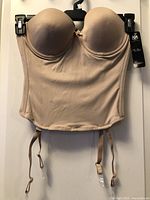 Front view of beige Va Bien strapless bustier with molded cups and garter straps