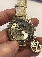 Front view of watch showing dial, bezel, strap and charm