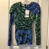 Front view of blue/green floral ruched long-sleeve Zara top with tag attached