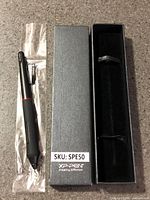 Stylus in plastic sleeve beside open storage box