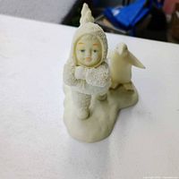 Snowbaby with crossed arms and penguin figurine