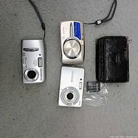 Group shot of three cameras, case and battery