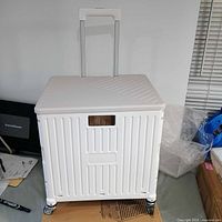 assembled beige foldable shopping cart on wheels with handle extended