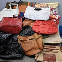 pile of assorted handbags showing variety of styles and colours