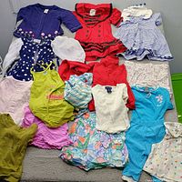Overview of all children’s clothing laid out on bed
