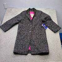 Full view of London Fog tweed coat laid flat showing exterior pattern and tag