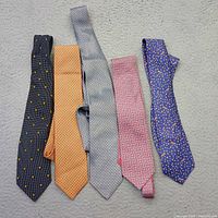 Five silk ties laid out showing colours and styles