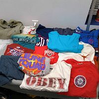 Group shot of all folded shirts showing graphics and colours