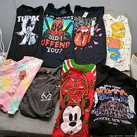 Nine t-shirts laid out showing graphics and colors