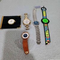 Group shot of wallet watch and four wristwatches