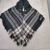 Full view of hooded striped shawl with fringe and toggles