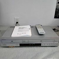 Front view of Sony SLV-D370P DVD/VHS combo with manual and remote on top