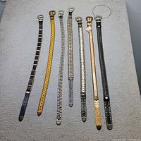 Seven belts laid flat side by side