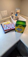 Overall view of markers, Spirograph kit, coloured paper, basket with supplies