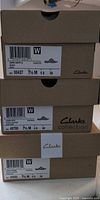 Three stacked Clarks shoe boxes with size labels visible