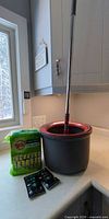 Mop bucket with handle, sponge pack, two Unstopables packets on countertop
