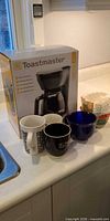 Boxed Toastmaster coffee maker, four mugs, coffee filters