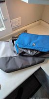Blue and grey insulated cooler bags folded on countertop