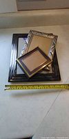 Three stacked photo frames with measuring tape for scale