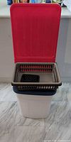 white plastic bin with red lid open, blue lid, brown and black baskets nested