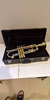 Open case showing Besson trumpet