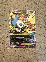 Front view of Mega Absol EX Pokémon card showing artwork, HP, attack and foil finish