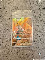 Front view of sealed Mimikyu promo card in plastic wrap showing artwork, stats, ability Safeguard and attack Ghost Eye