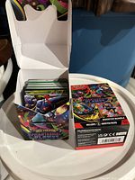 Open deck box filled with Pokémon cards next to sealed Booster Bundle box