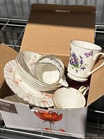 Box containing assorted floral teacups, saucers, mug and gravy boat
