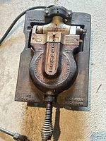 Top view of cast iron waffle press with cord attached