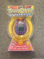 Front of sealed Bandai Tamagotchi Connection virtual pet, purple shell in blister pack