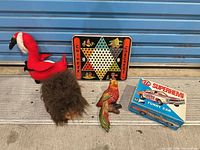 Group shot showing Chinese Checkers board, STP Superhemi box, plush flamingo, furry puppet head, ceramic parrot