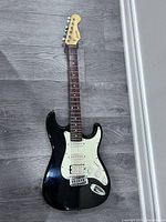 Full view of Baron black electric guitar on floor