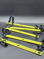 Full view of yellow rung agility ladder with black straps