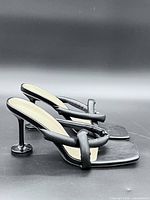 side view of both heels showing padded straps, square toes and sculptural heels