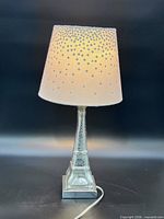 Full view of lamp lit showing Eiffel Tower base and shade