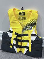Front view of yellow and black Fluid adult medium life vest showing buckles and reflective accents