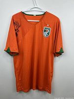 Full front view of orange Côte d'Ivoire jersey on hanger