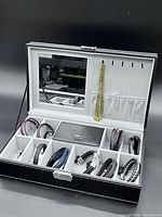 Open jewelry case showing mirror, interior compartments and contents