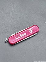 Closed multitool showing L.L. Bean logo and Swiss emblem on red scale