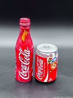 Front of red Coca-Cola aluminum bottle and Japanese mini can