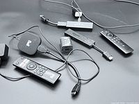 Lot overview showing streaming sticks, remotes, power adapter, cables