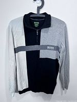 Full front view of colour-blocked quarter-zip sweater on hanger