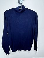 Front view of blue turtleneck sweater on hanger