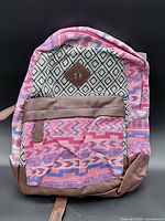 Front view of Ardene patterned backpack showing fabric design, pocket, faux-leather base and straps
