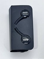 Earphones in holder showing AKG logos