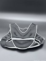 Front view of black and grey weighted vest laid flat