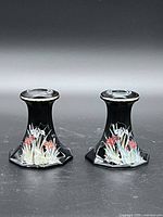 pair of black Japanese floral candlesticks front view