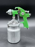 Left side view of Profix green spray gun with attached metal cup
